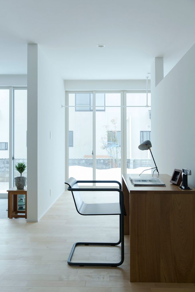 お気に入りの家具がシンプルな空間に映える。奥の窓辺はサンルーム。