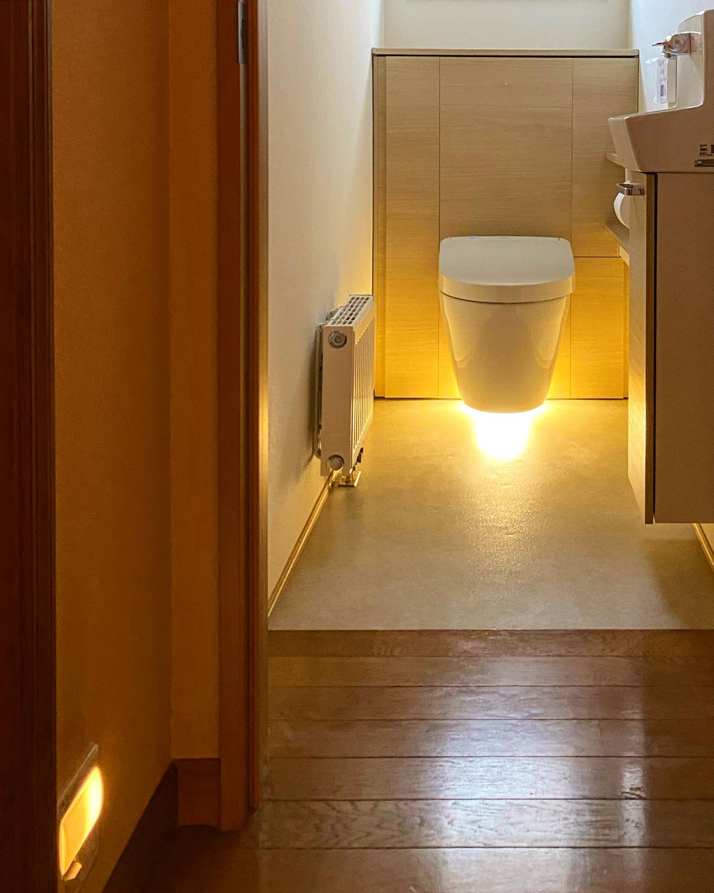 フローティングデザインのトイレはフロアライトで浮遊感を演出するとともに個室に広がりをもたらせた。